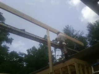 Carpenter setting a ridge beam over a new addition frame — Ice Dam Removal by Roofing Brothers in North Fairfield