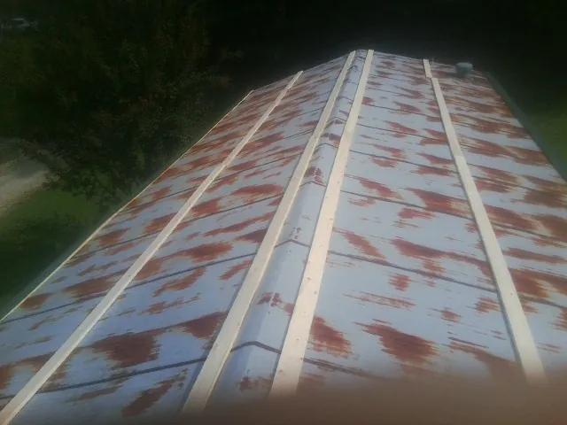 Rusted metal roof panels with new wood purlins before replacement — Storm Damage Roof Repair in North Fairfield by Roofing Brothers