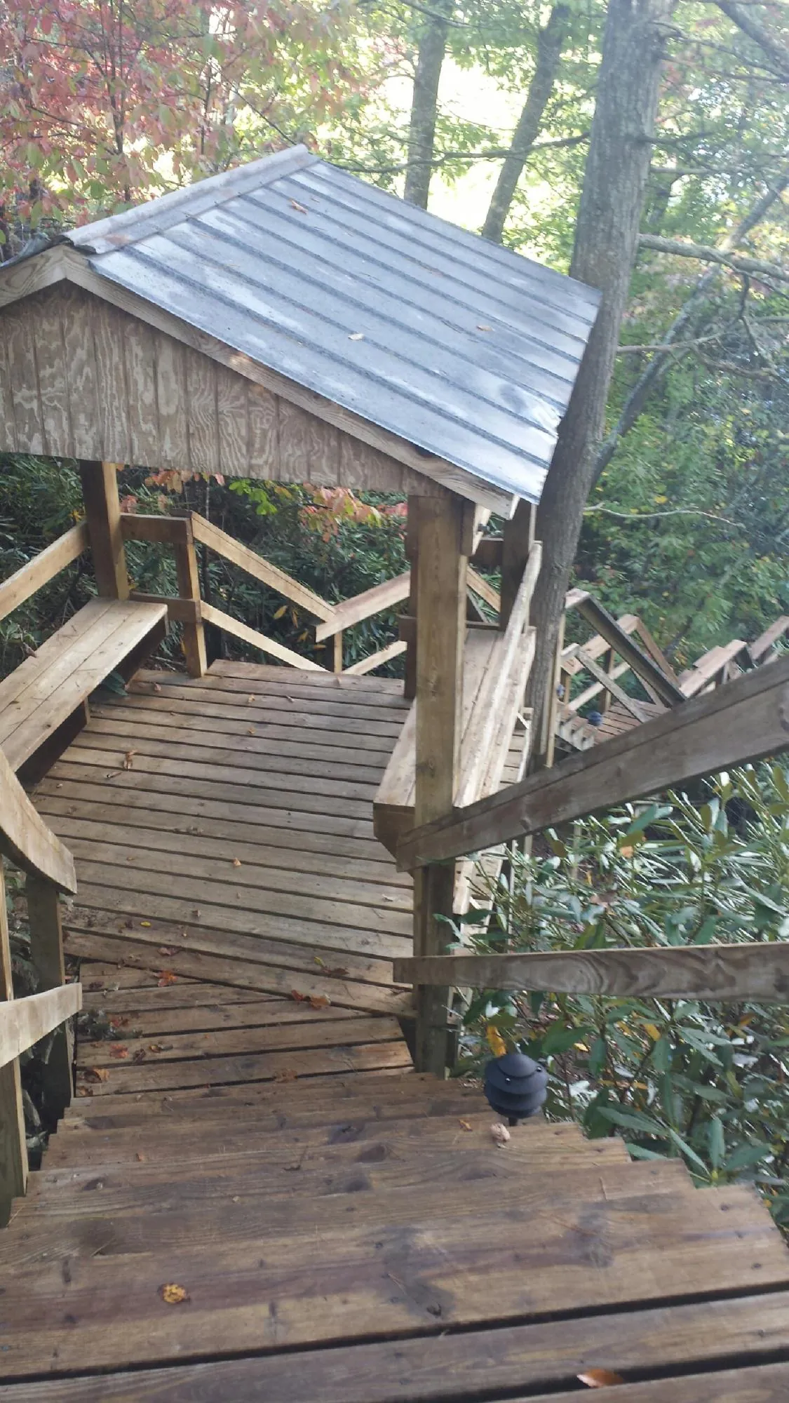 Metal roofed shelter over wooden steps on a wooded walkway — Skylight Repair & Installation work by our crew in North Fairfield